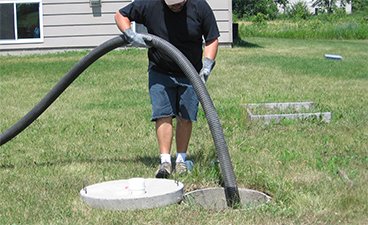 Person holding hose to clean septic system